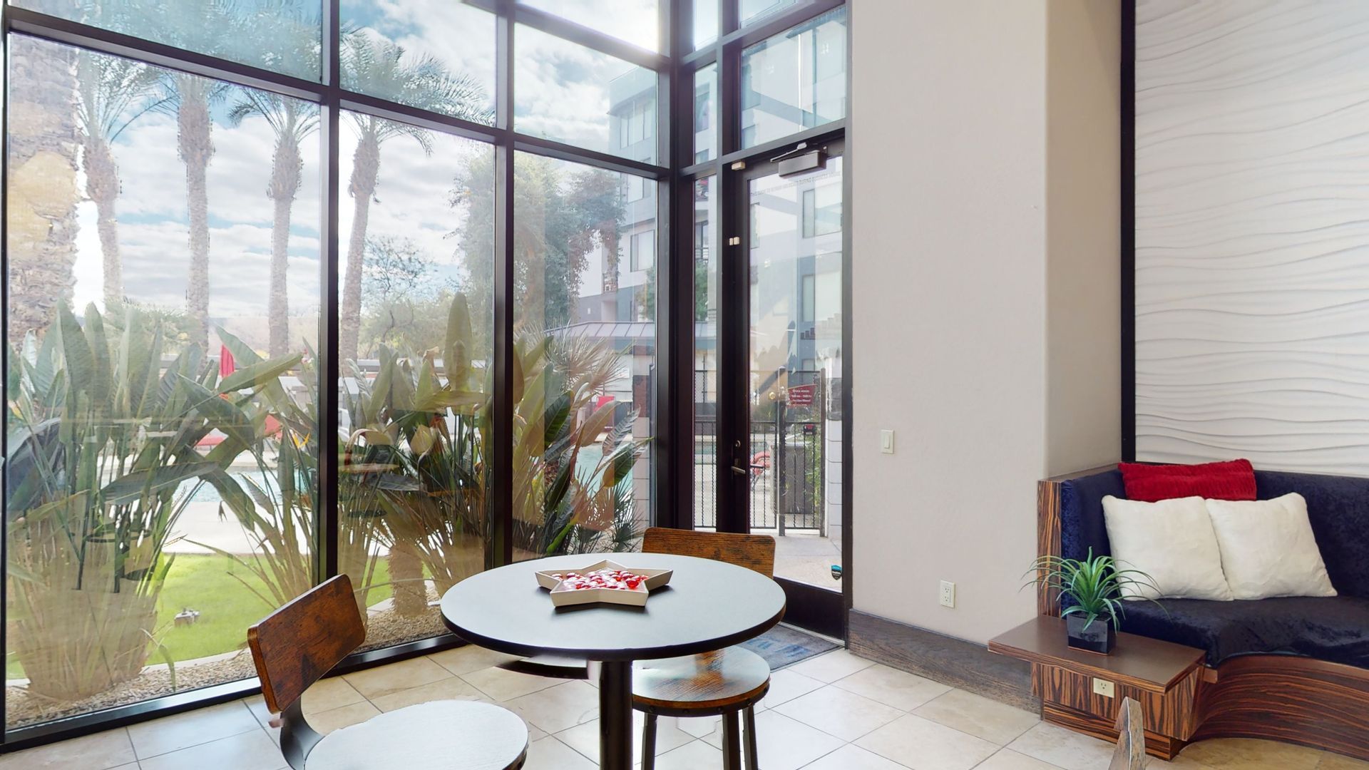 A living room with a table and chairs in front of a large window.