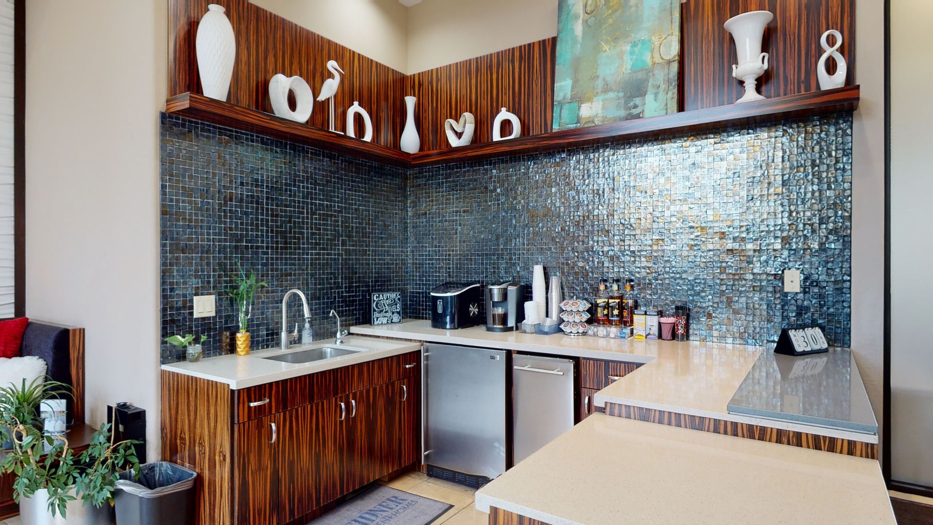 A kitchen with wooden cabinets , stainless steel appliances , a sink , and a table.