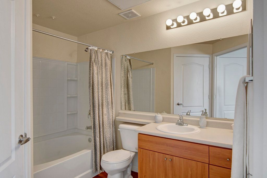 A bathroom with a toilet , sink , and bathtub.