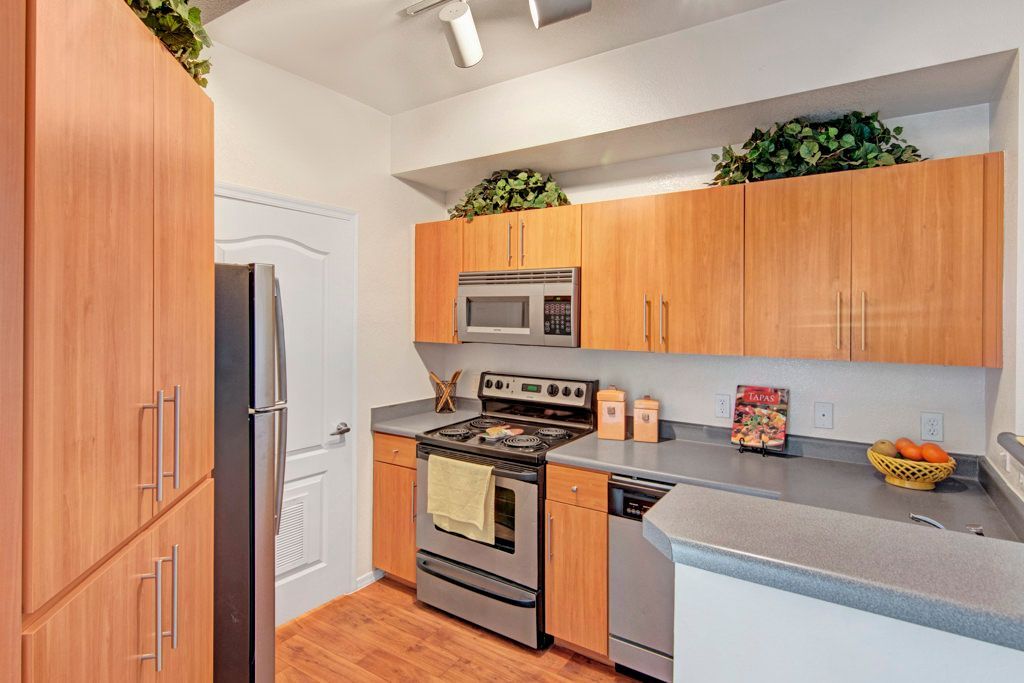 A kitchen with stainless steel appliances and wooden cabinets