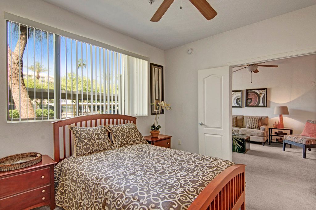 A bedroom with a king size bed and a ceiling fan