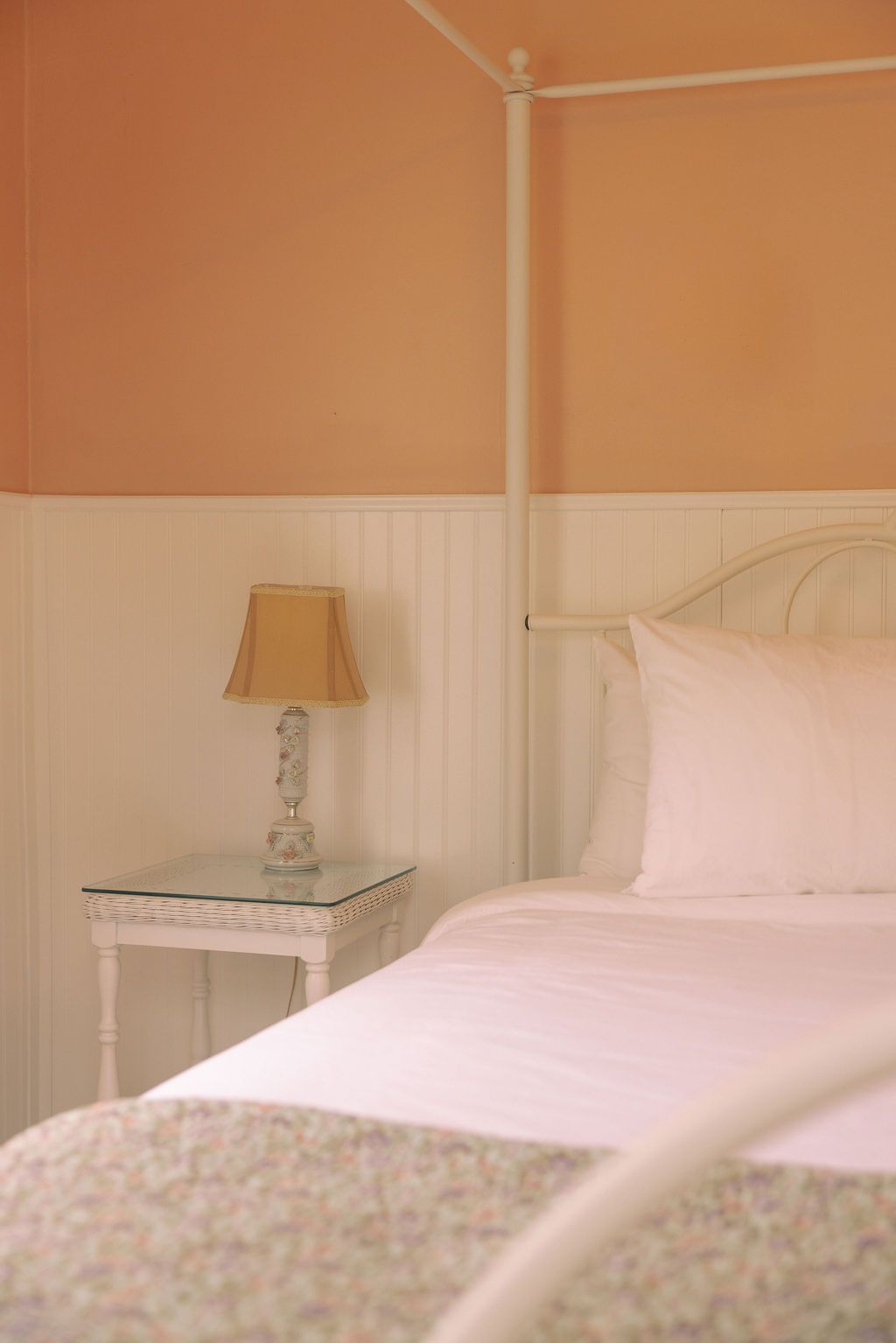 A bedroom with a bed , two windows and a chandelier.