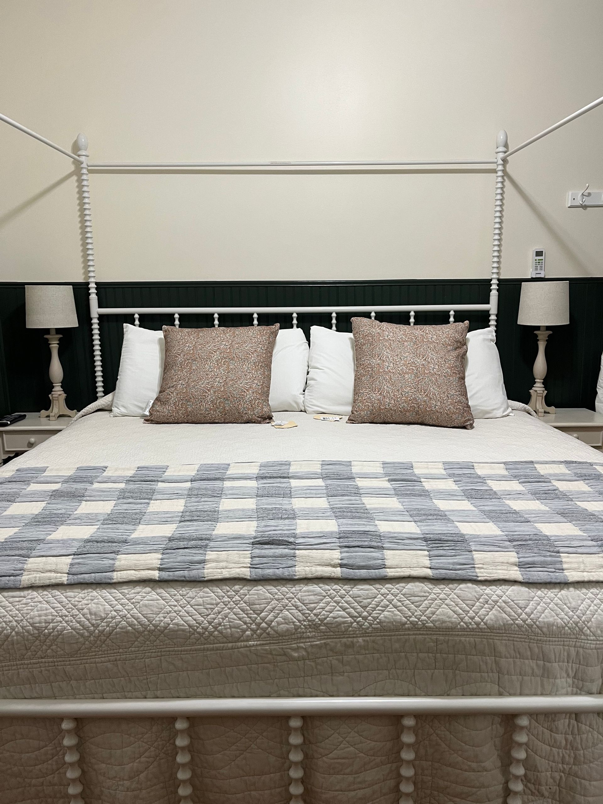 A bed with a checkered blanket and pillows in a bedroom.