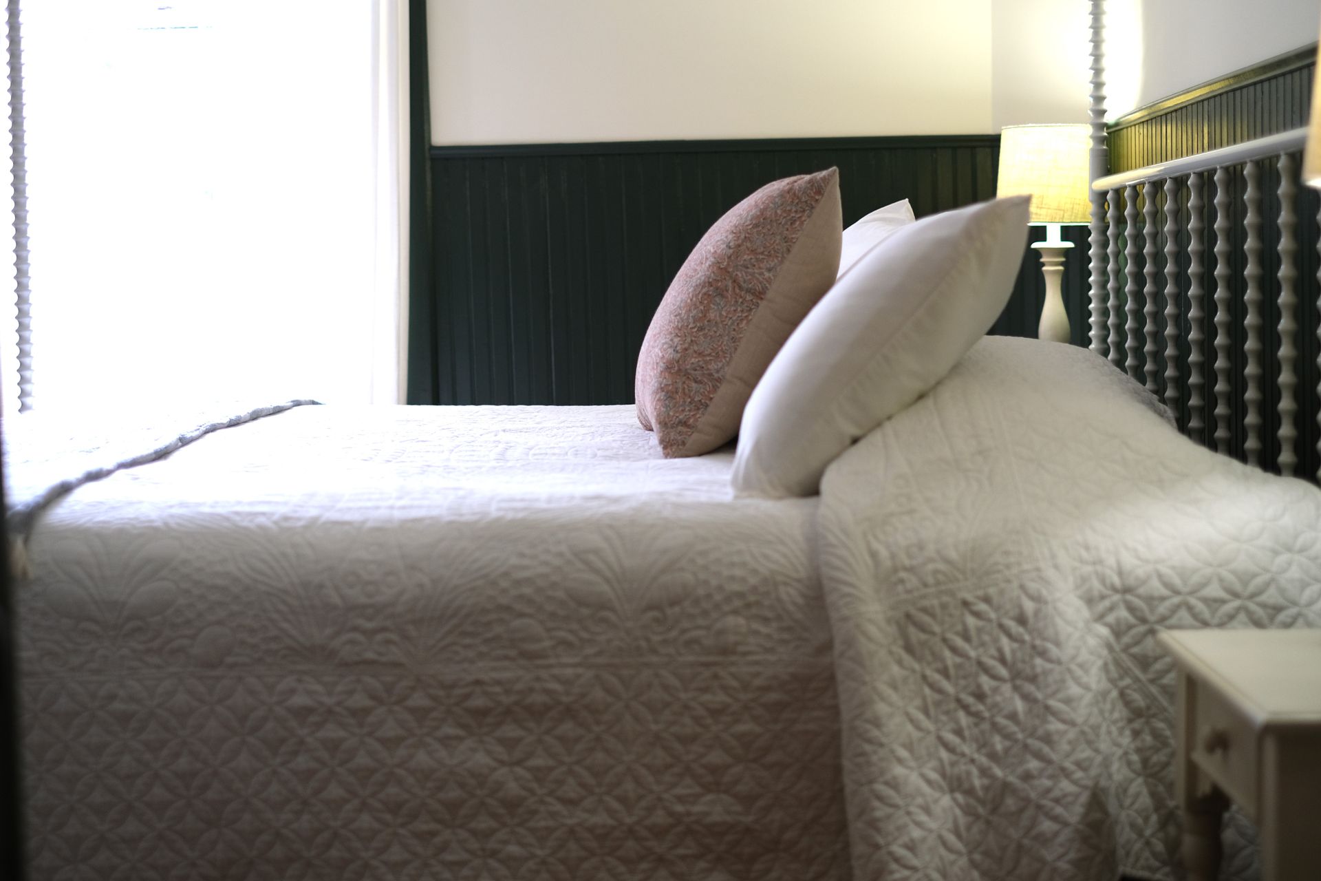 A bed with a checkered blanket and pillows in a bedroom.