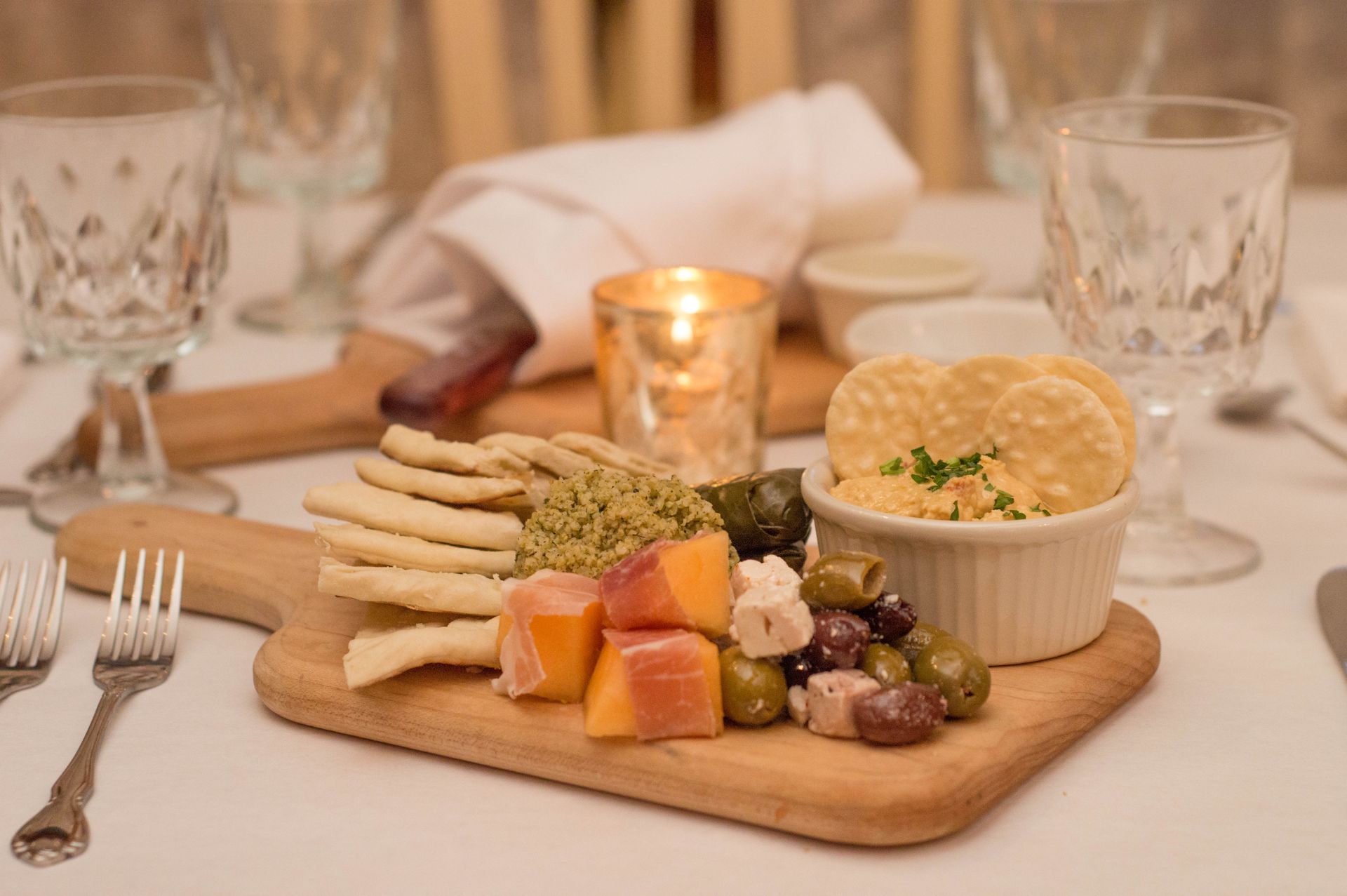 A wooden cutting board topped with a variety of food on a table.