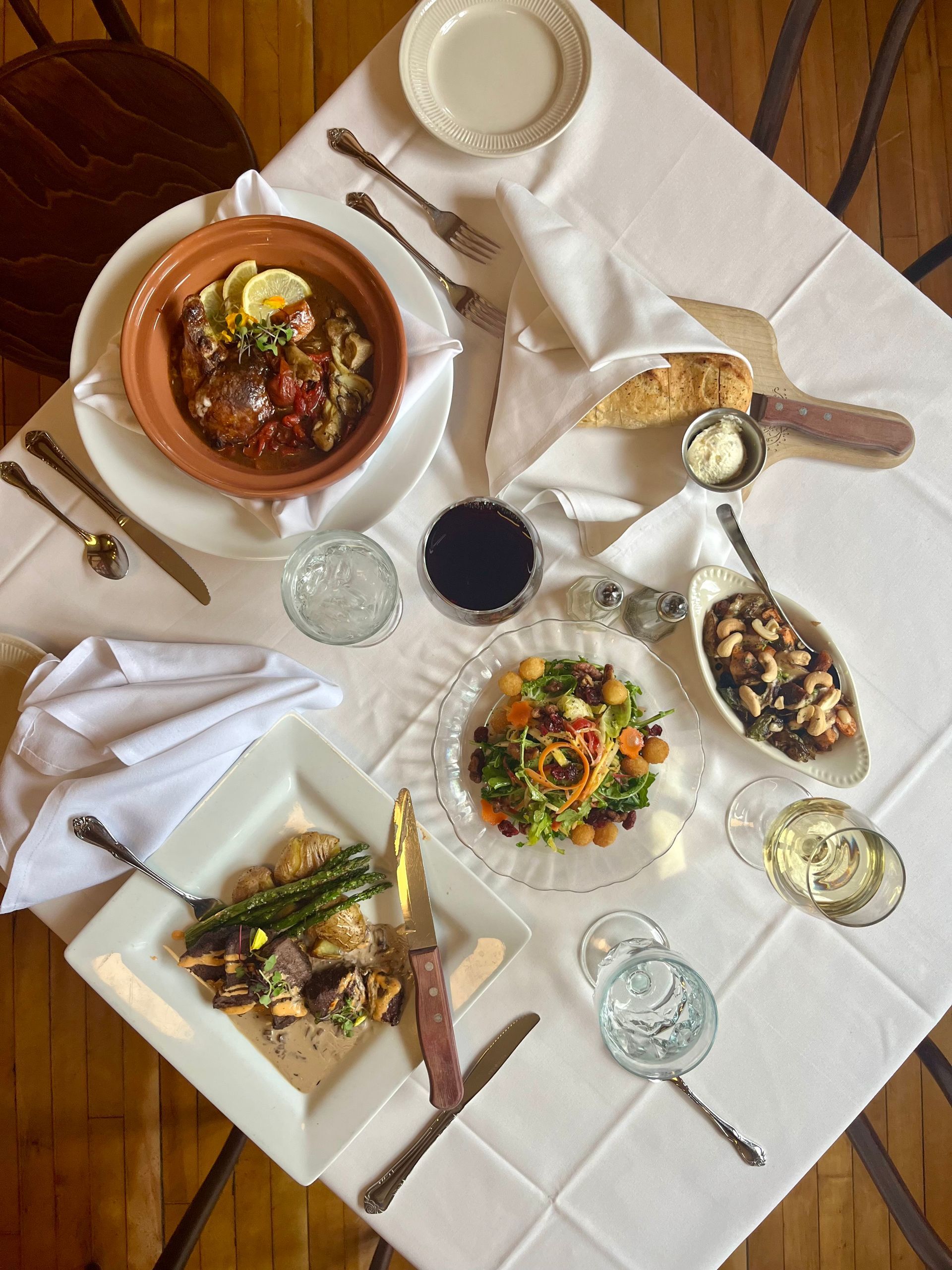 A table topped with plates of food and wine glasses