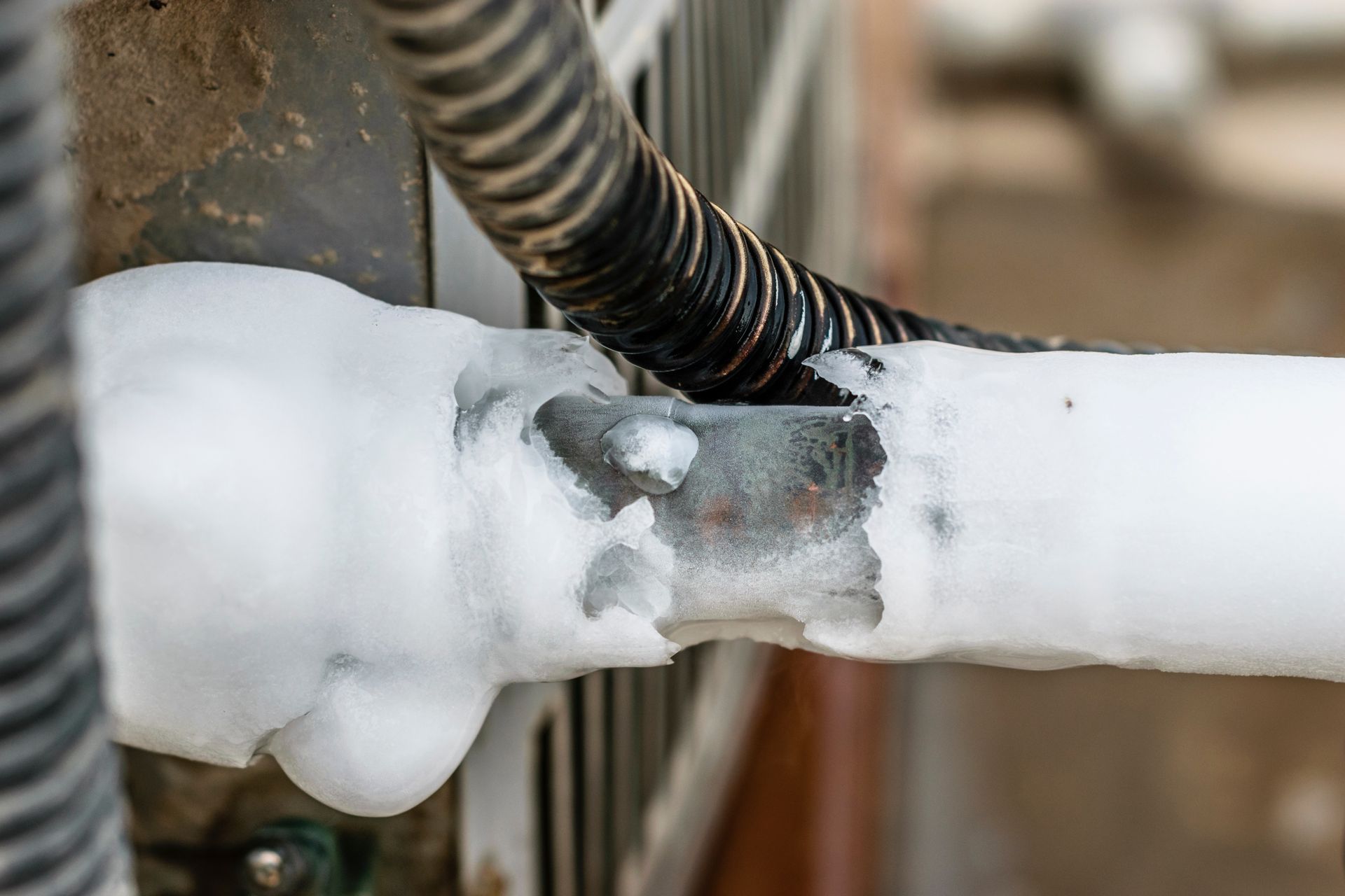 Frozen air conditioner pipe with white frost.