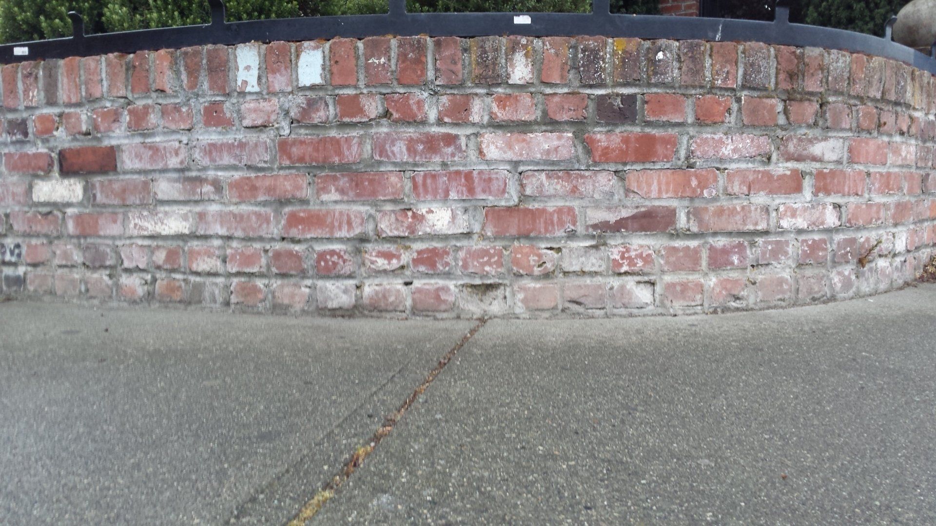 A garden retaining wall curved and made of brick.