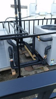A couple of air conditioners are sitting on top of a roof.
