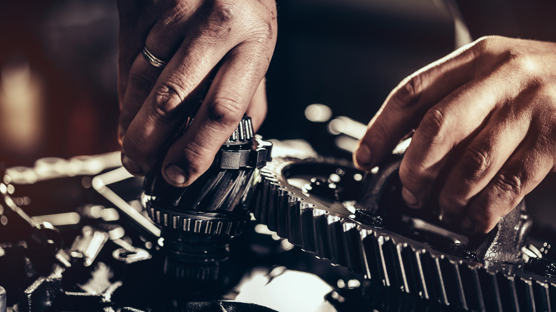 A man is working on a gear on a machine.