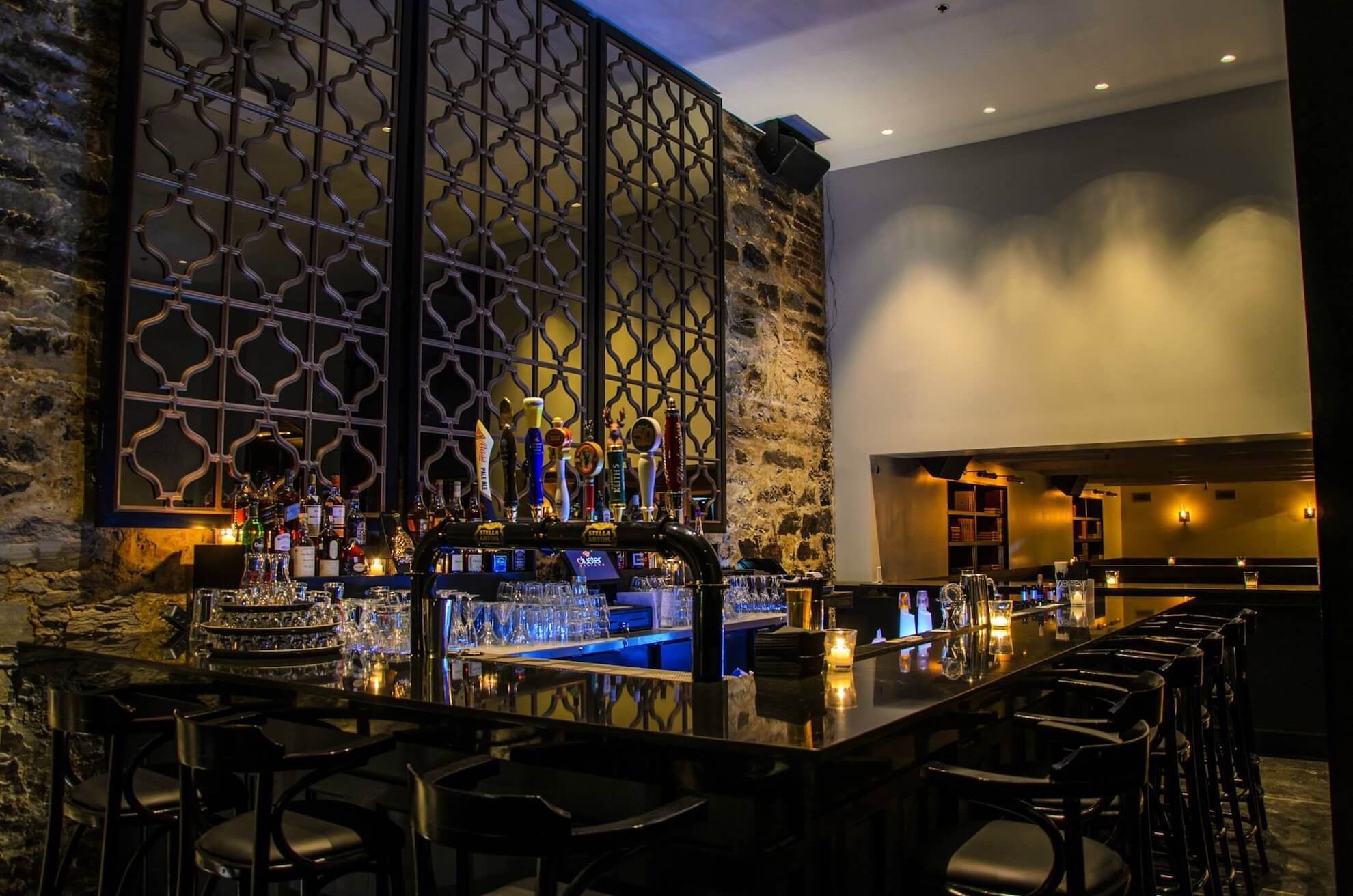 Un bar dans un restaurant avec un long comptoir et des tabourets.