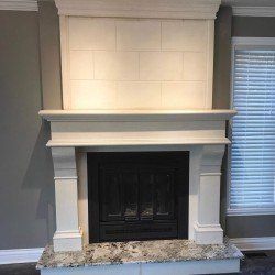 Cheminée en pierre blanche avec foyer foncé et foyer en granit.