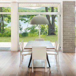 Salle à manger avec table et chaises face à une grande fenêtre donnant sur un lac.