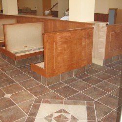 Banquette de restaurant avec sol en carrelage marron et boiseries.