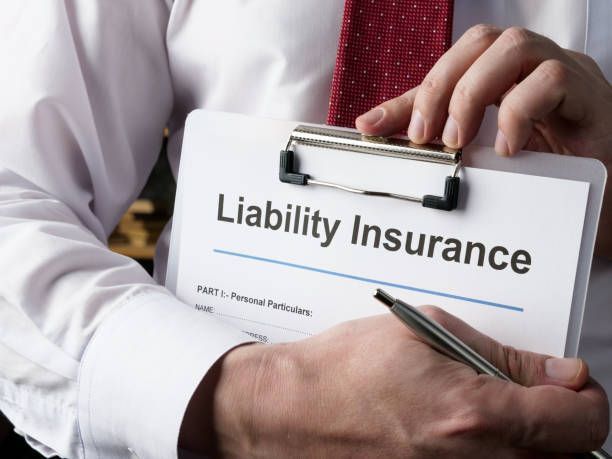 Business owner reviewing general liability insurance policy with a pen in hand.