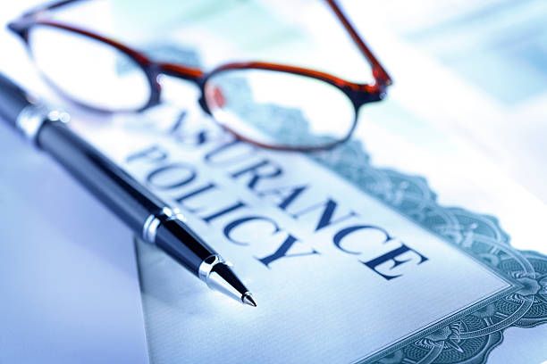 Ballpoint pen and eyeglasses resting on a general liability insurance policy document.