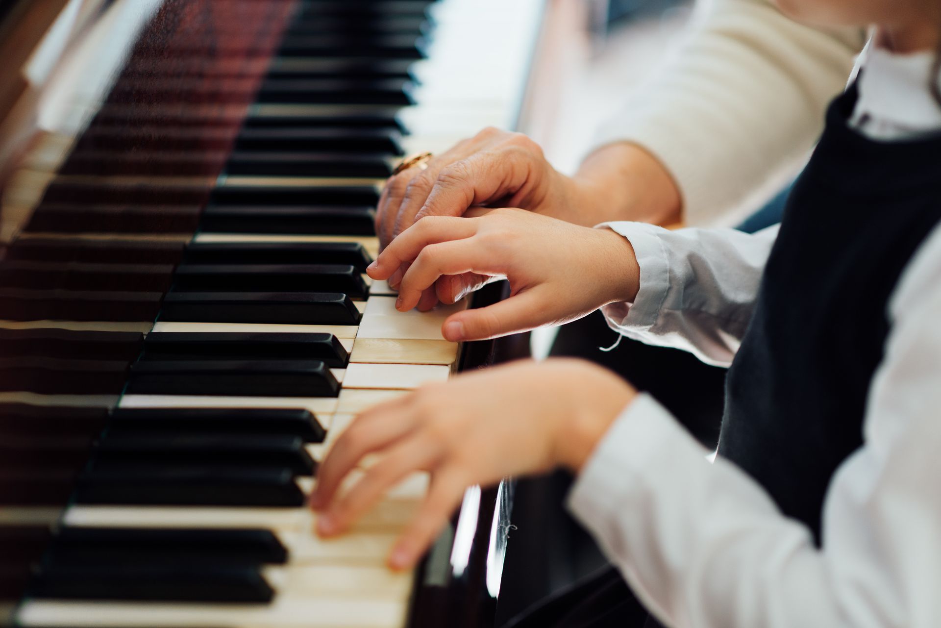 Hands playing a piano keyboard in a close-up view