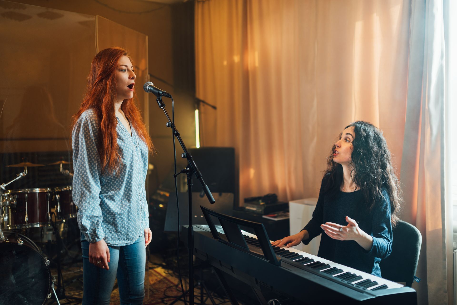 Singer and pianist rehearsing in a warm-lit music studio