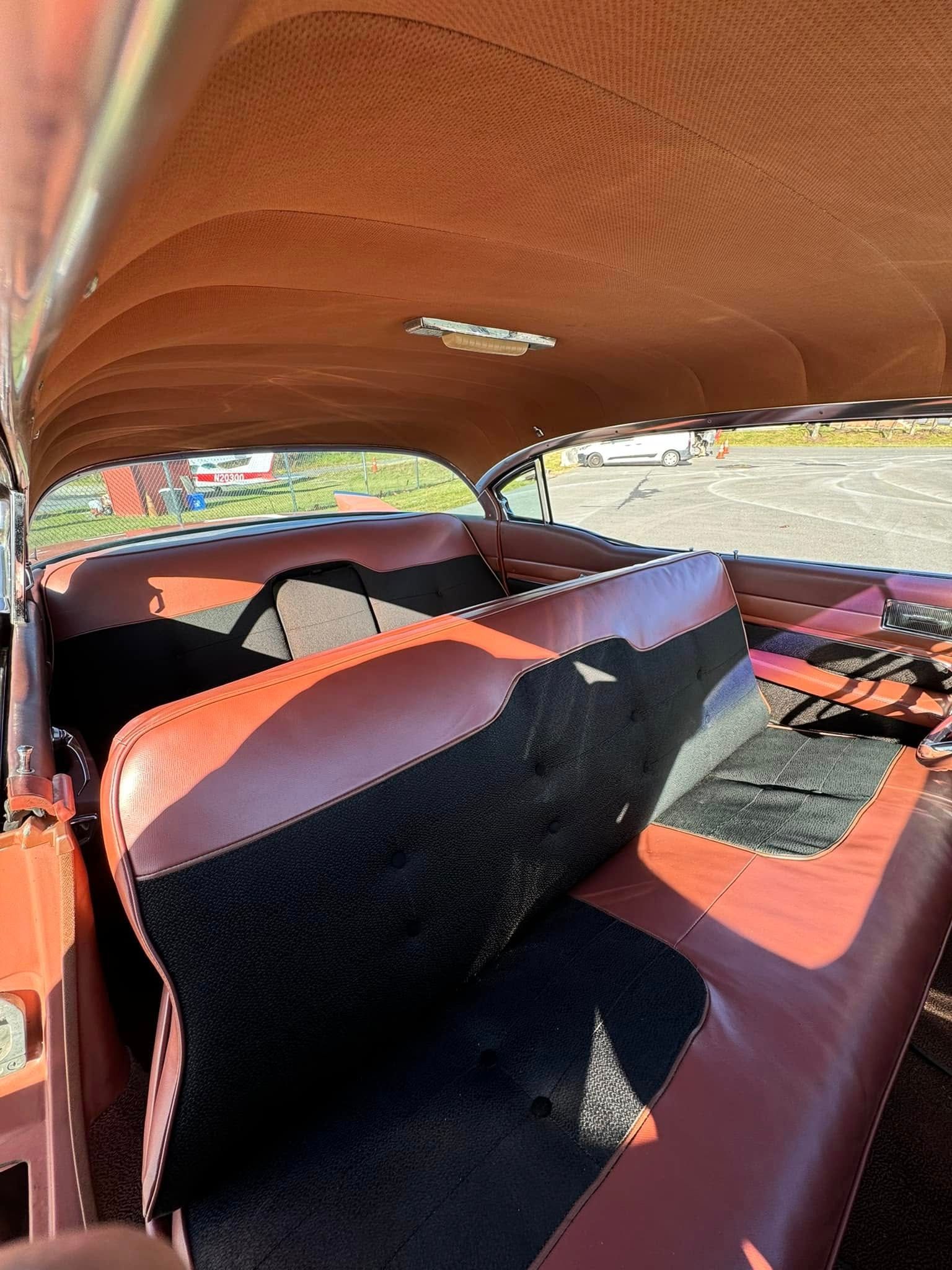 The inside of a car with brown and black seats and a roof.