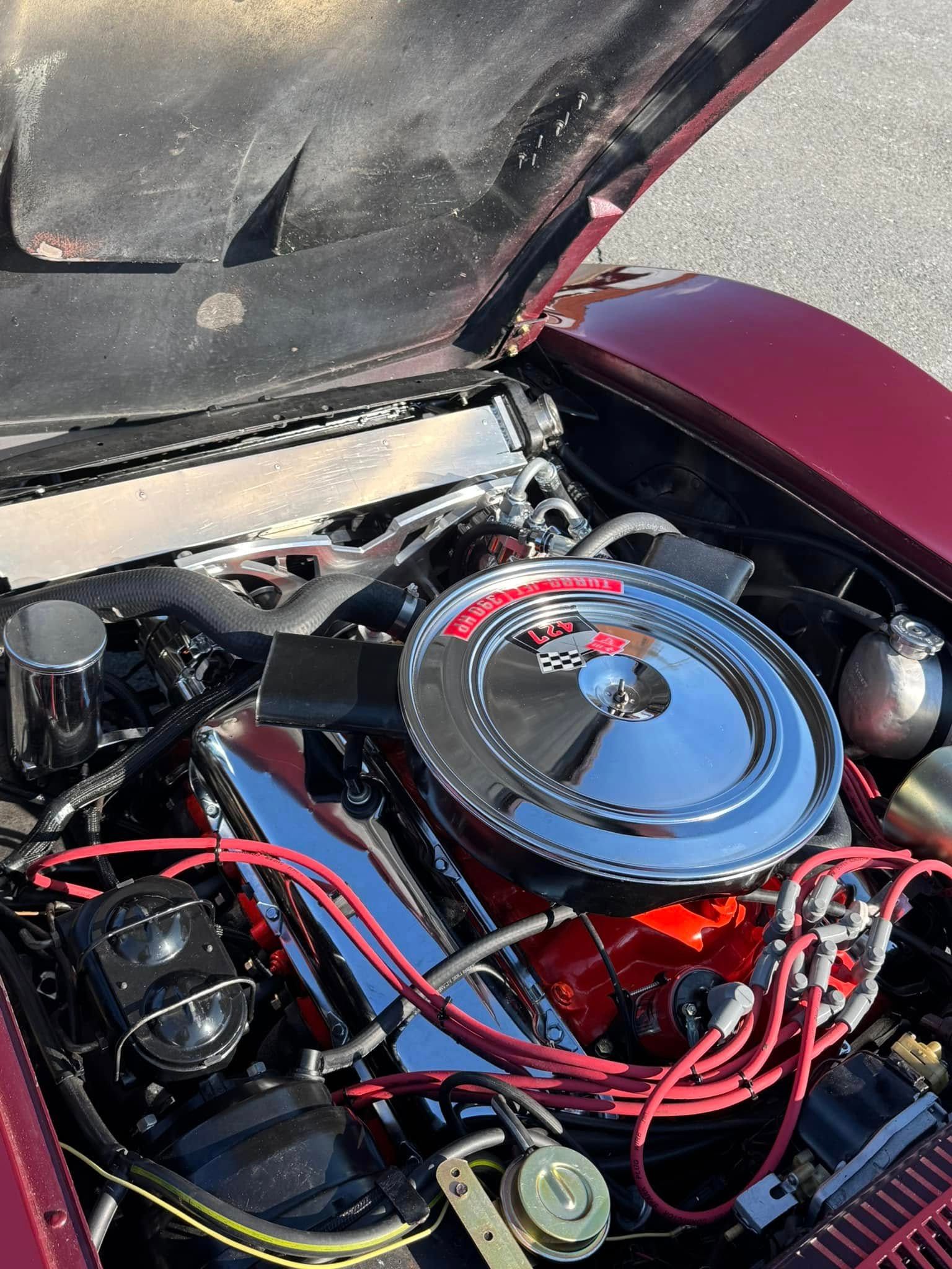 A close up of a car engine with the hood open