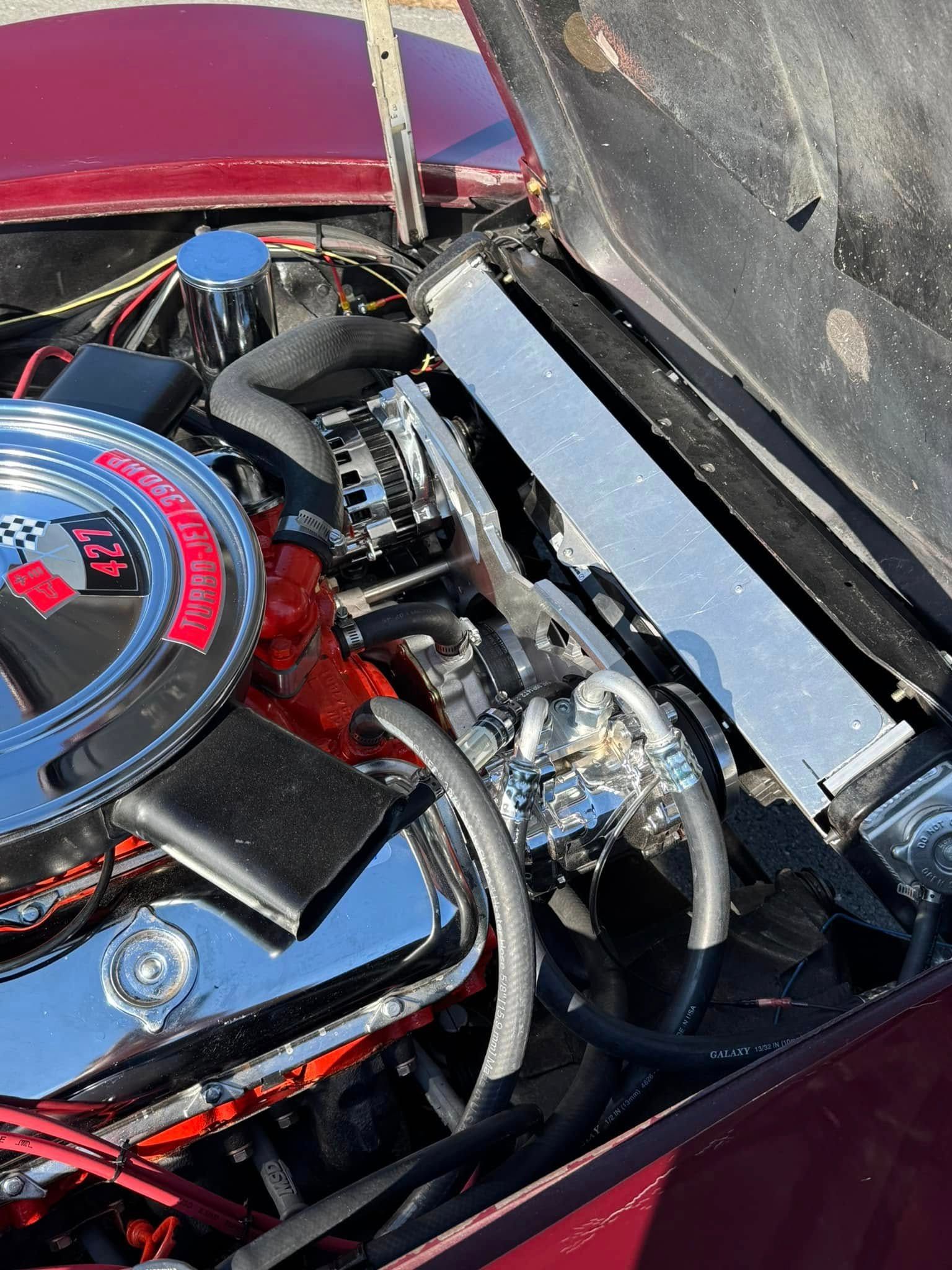 A close up of a car engine with the hood open.