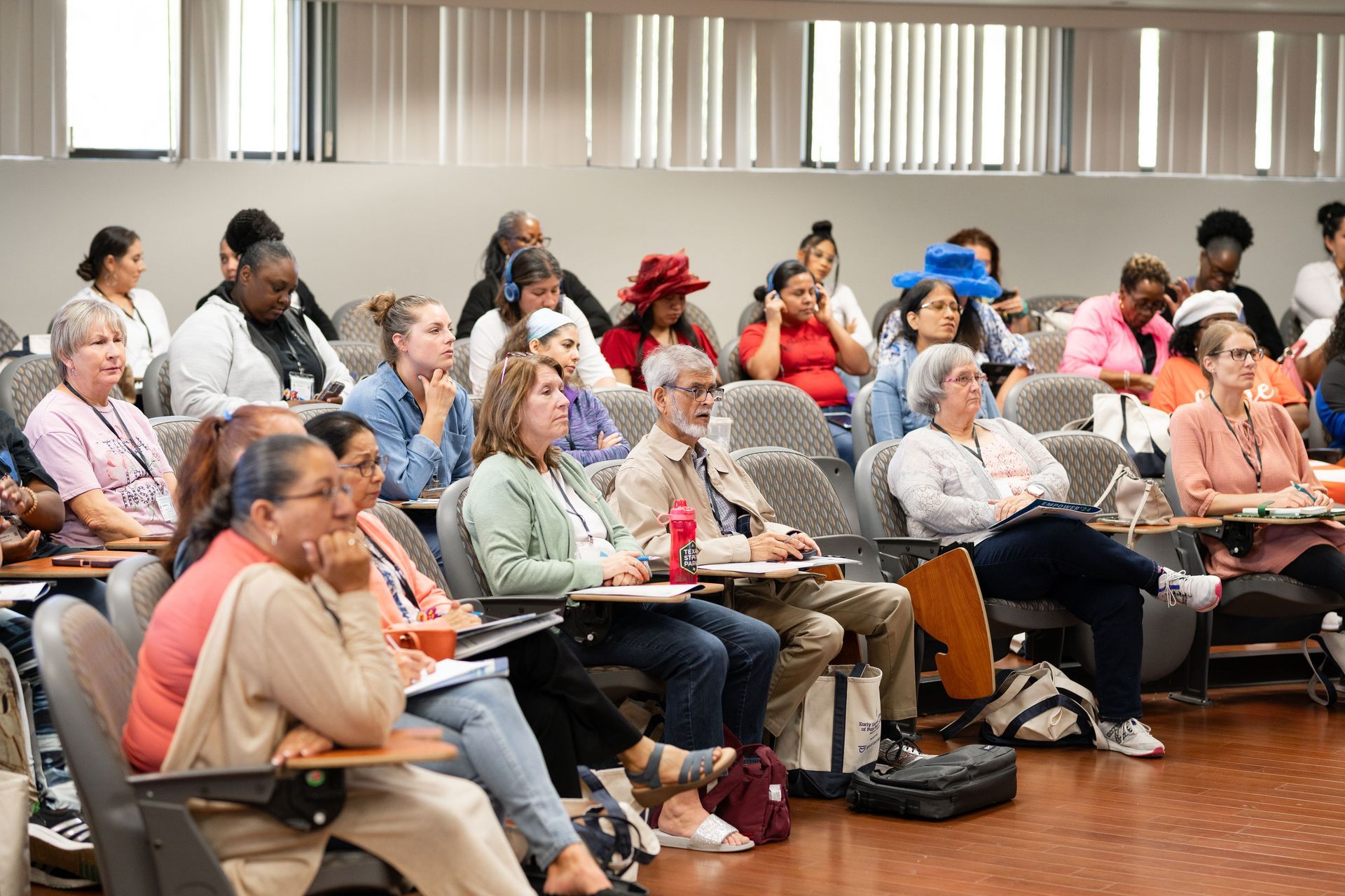 A large group of people are sitting in a lecture hall.