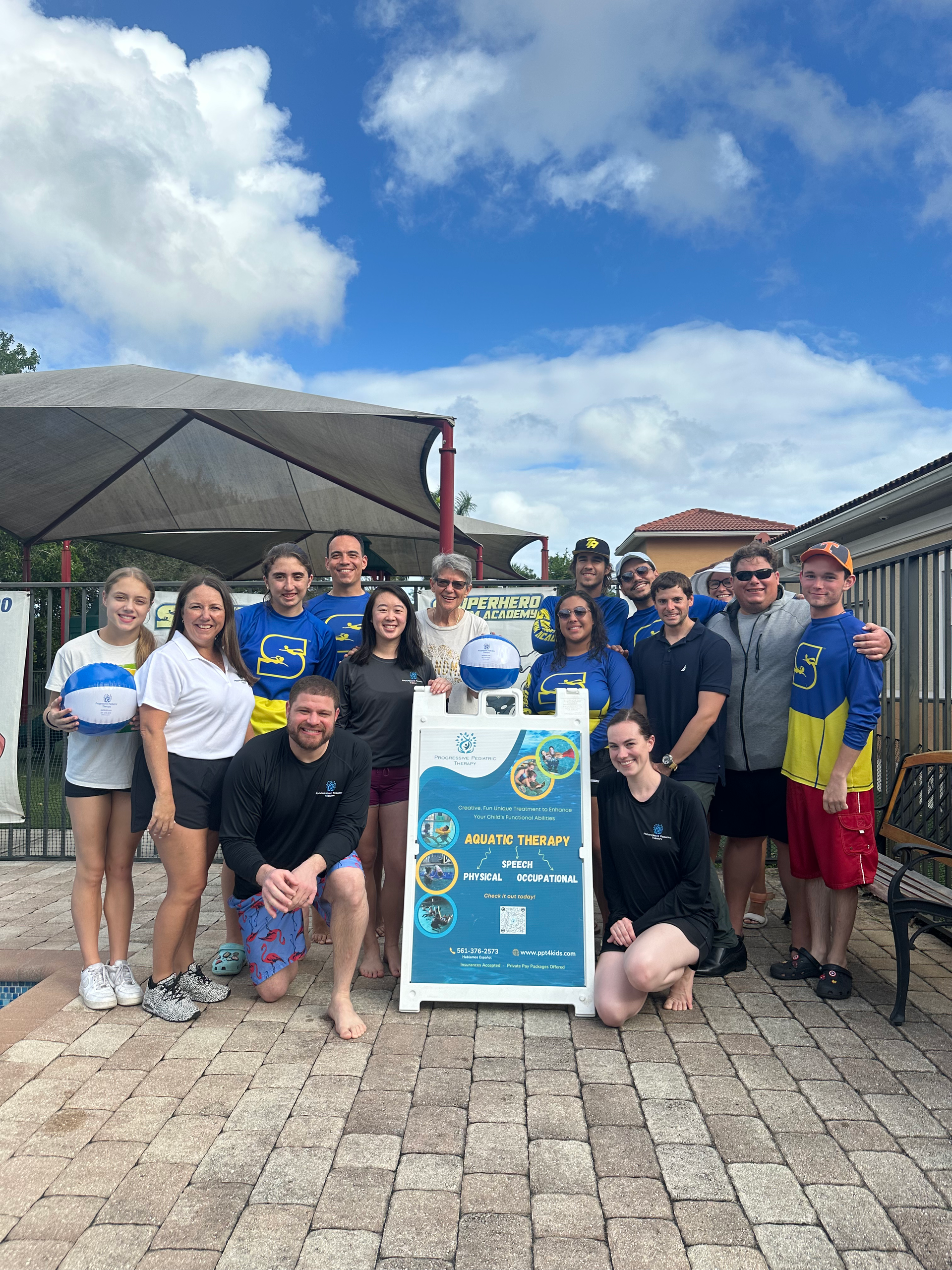 A group of people are posing for a picture in front of a sign.