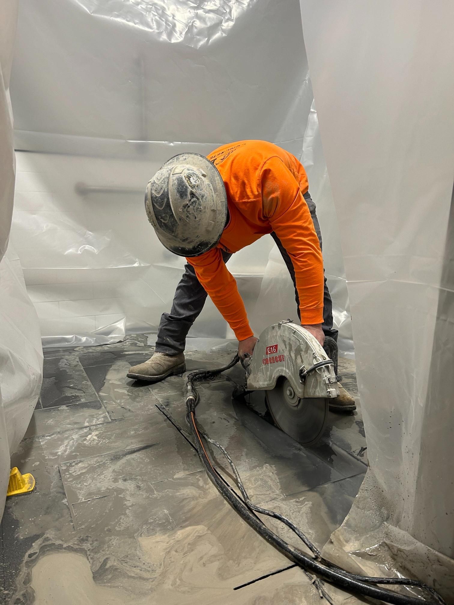 A man is cutting concrete with a circular saw.