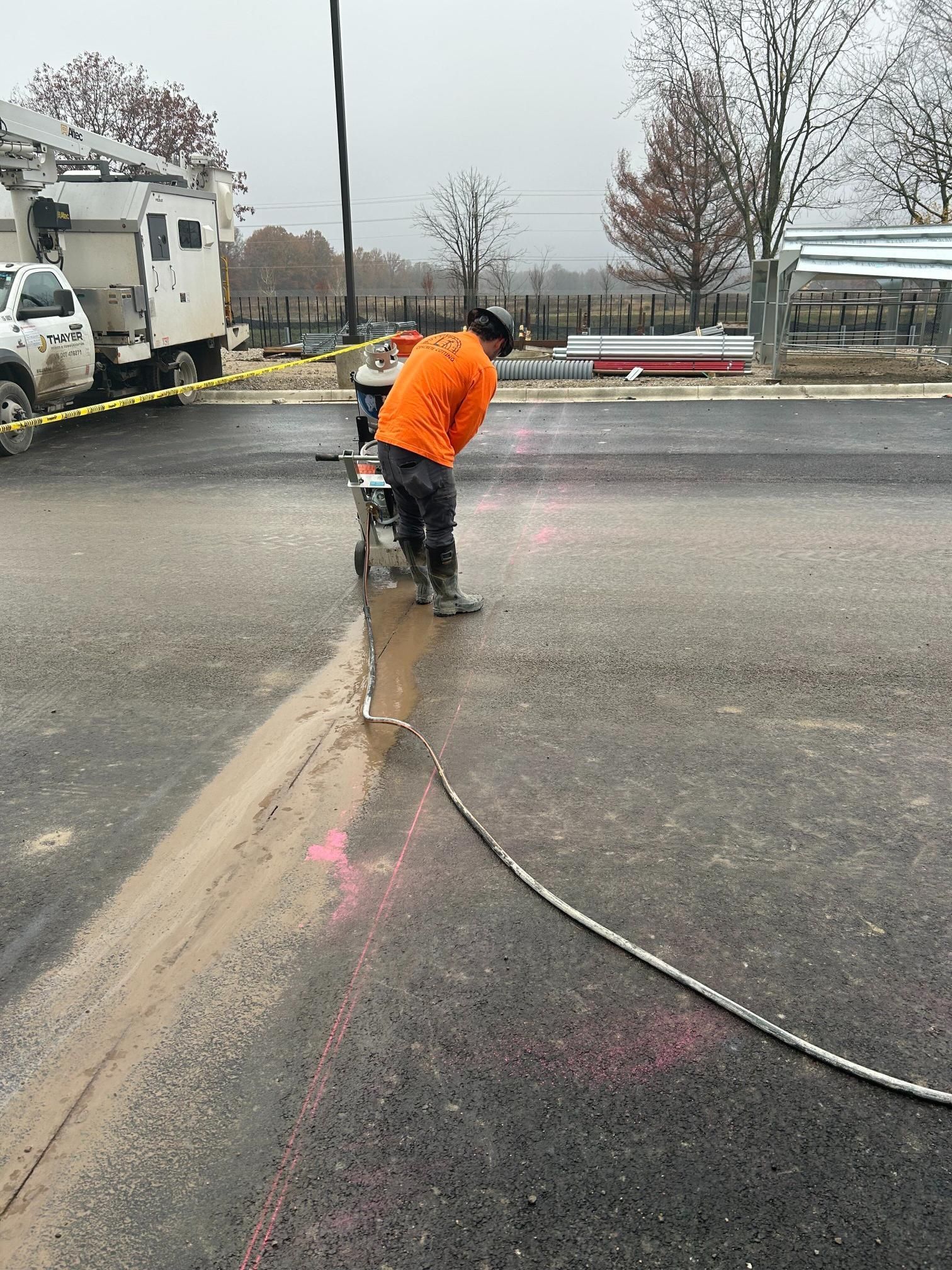 A man is kneeling down in the middle of a road.