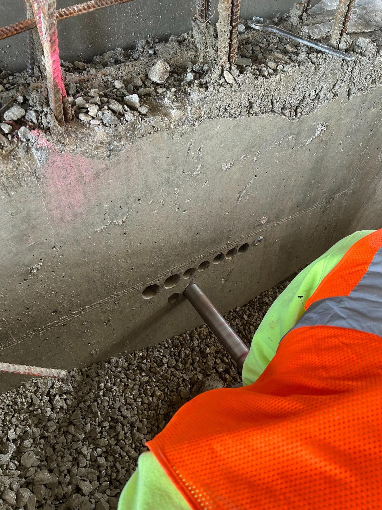 A construction worker is working on a concrete wall.