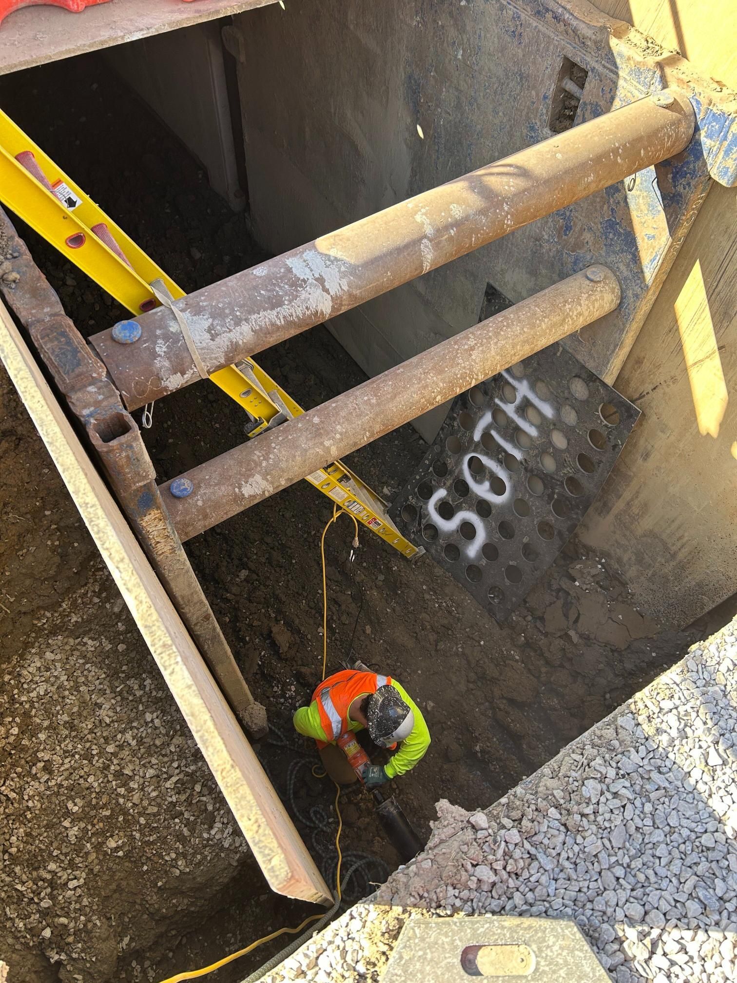 A man is standing in a hole with the word soth painted on the wall.