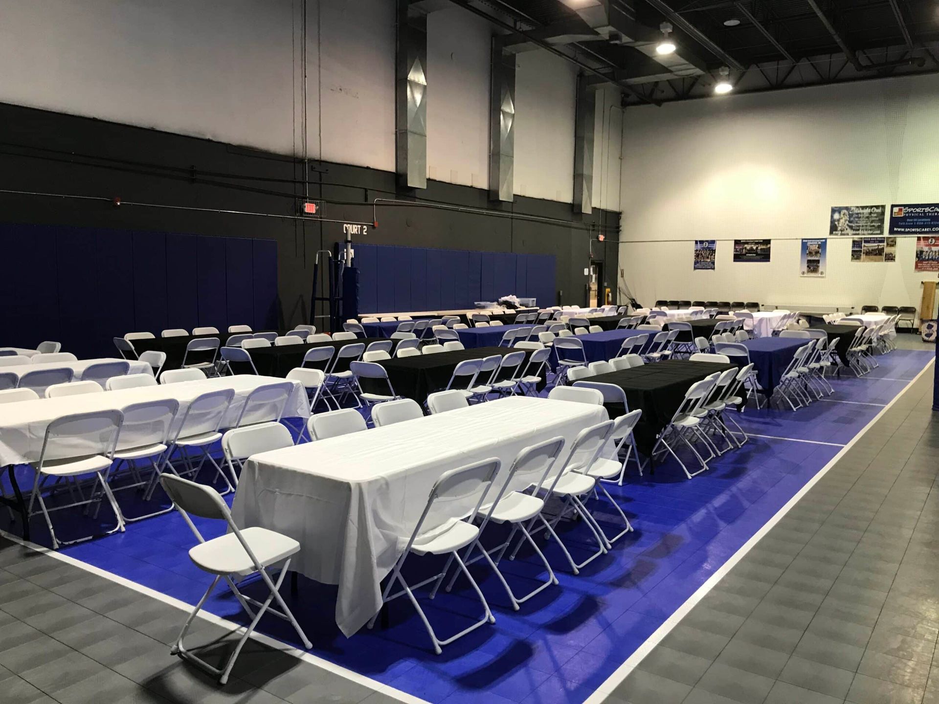 A large room with tables and chairs set up for a party.