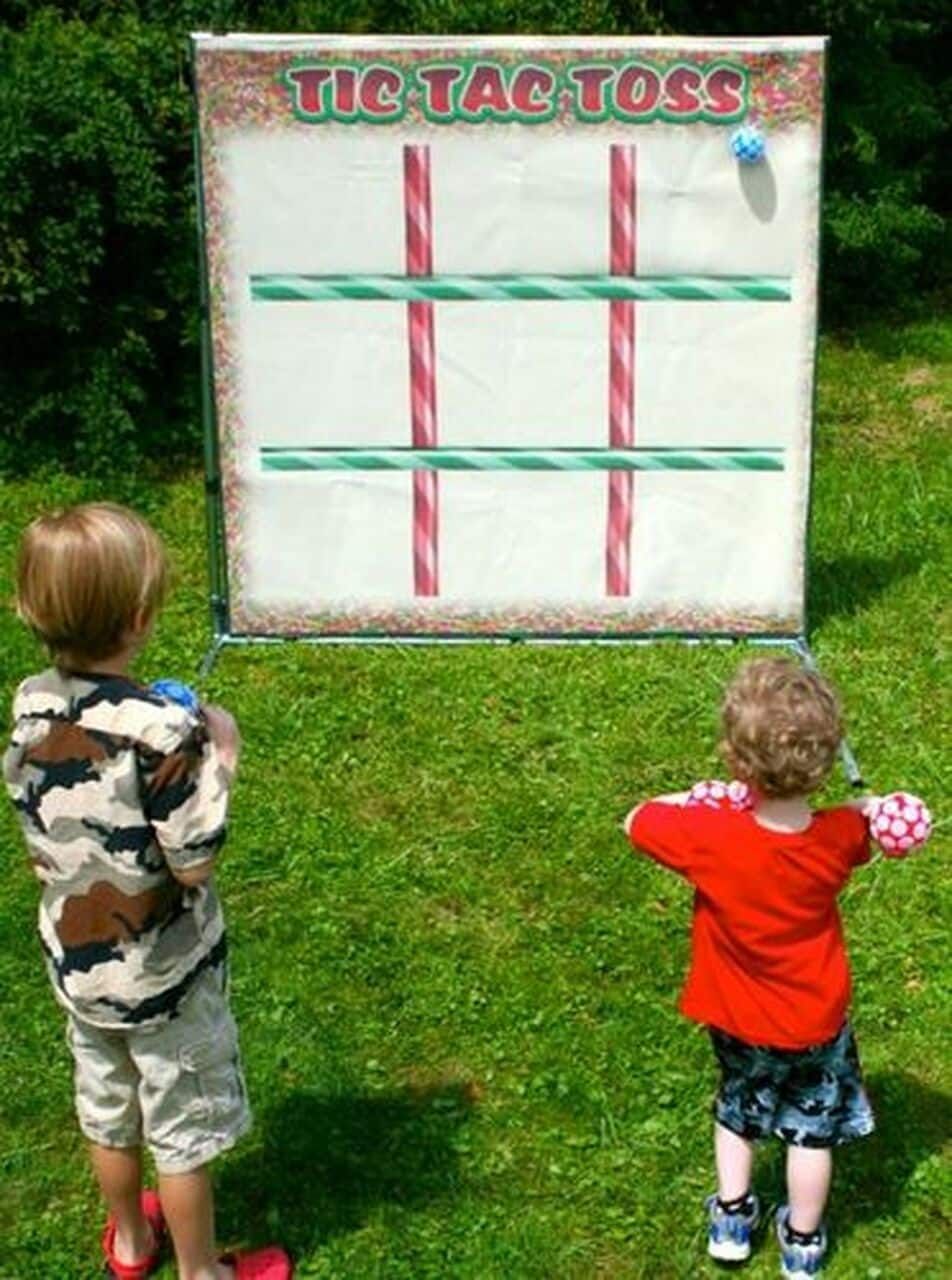 Two children are playing tic tac toss in the grass