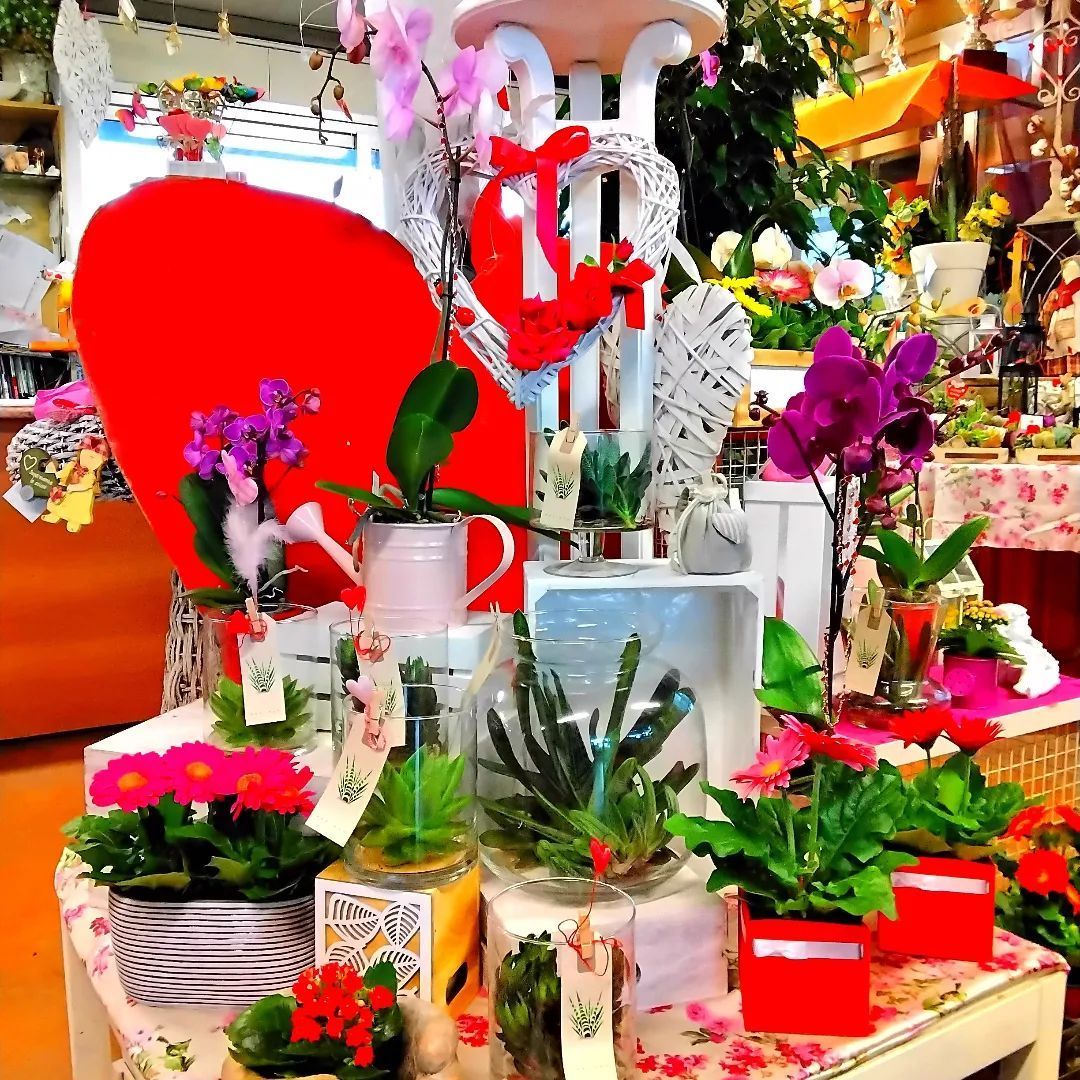 Una esposizione di fiori e un cuore rosso in un negozio
