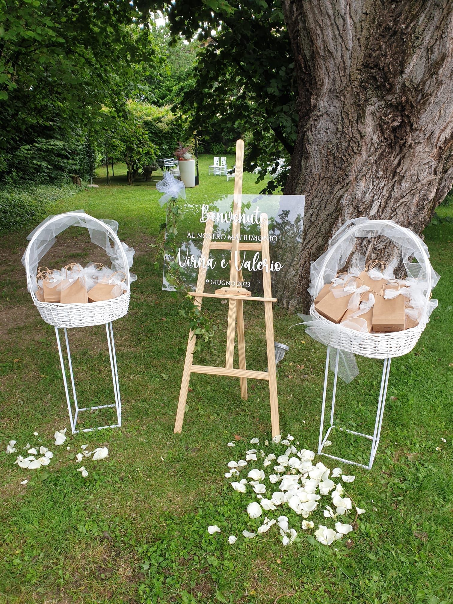 Due cesti sono appoggiati sull'erba accanto a un cavalletto di legno.