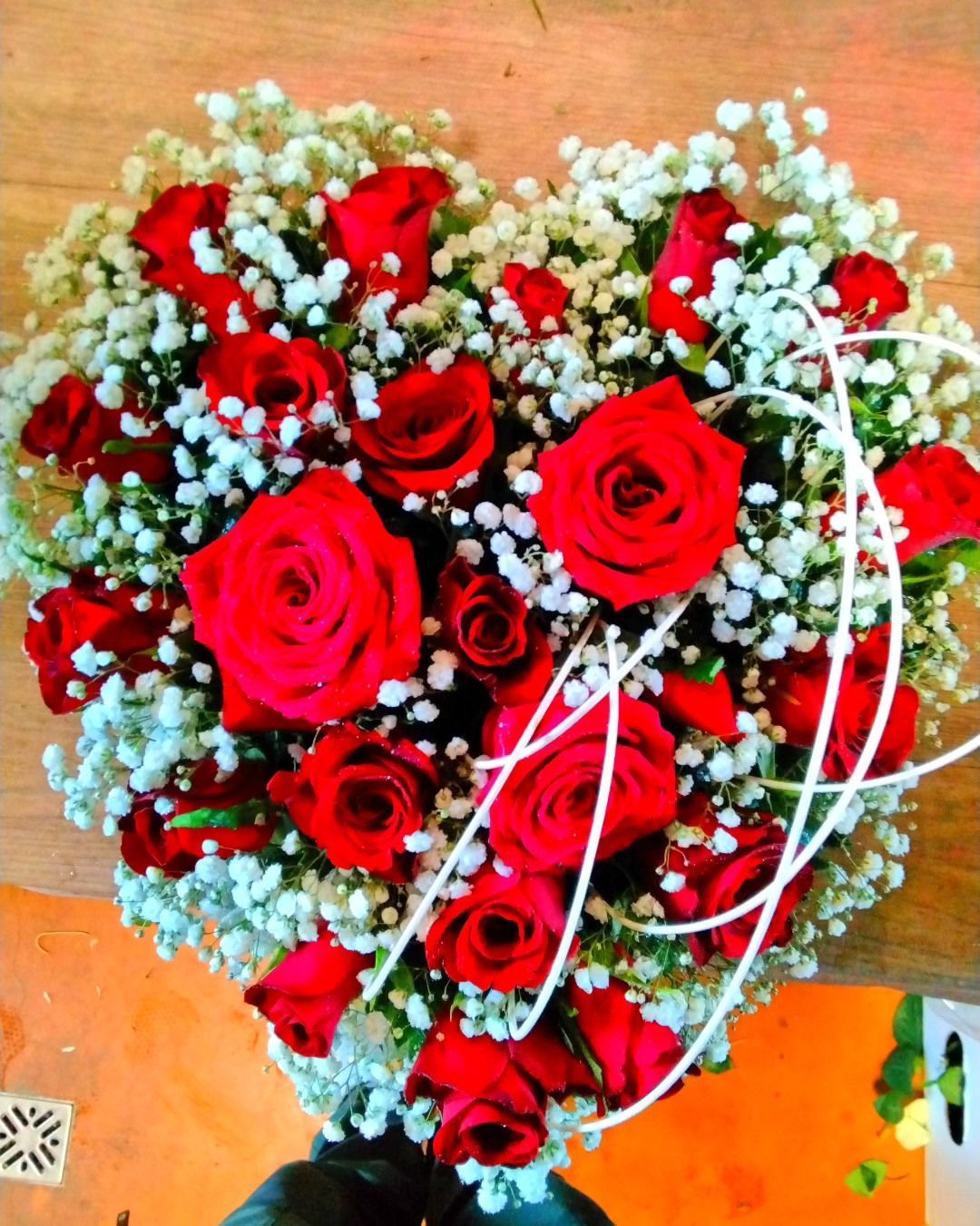Un bouquet a forma di cuore di rose rosse e gypsophila