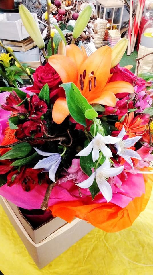 Un mazzo di fiori è in una scatola su un tavolo.