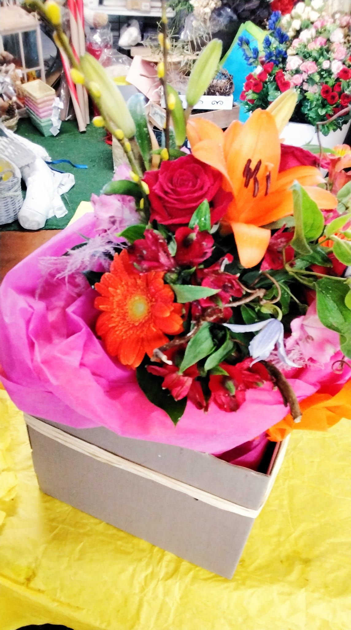 Una scatola piena di fiori è appoggiata su un tavolo.