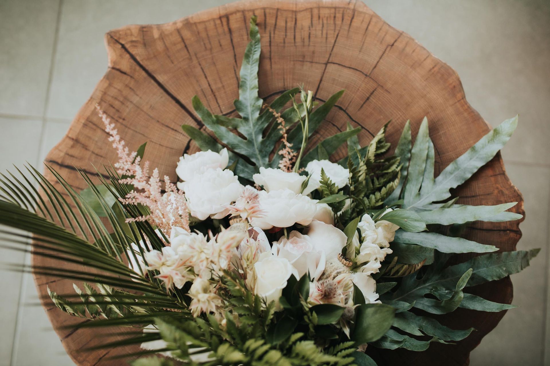 Un mazzo di fiori è appoggiato su un ceppo di legno.