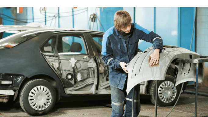 A man is working on a car in a garage.