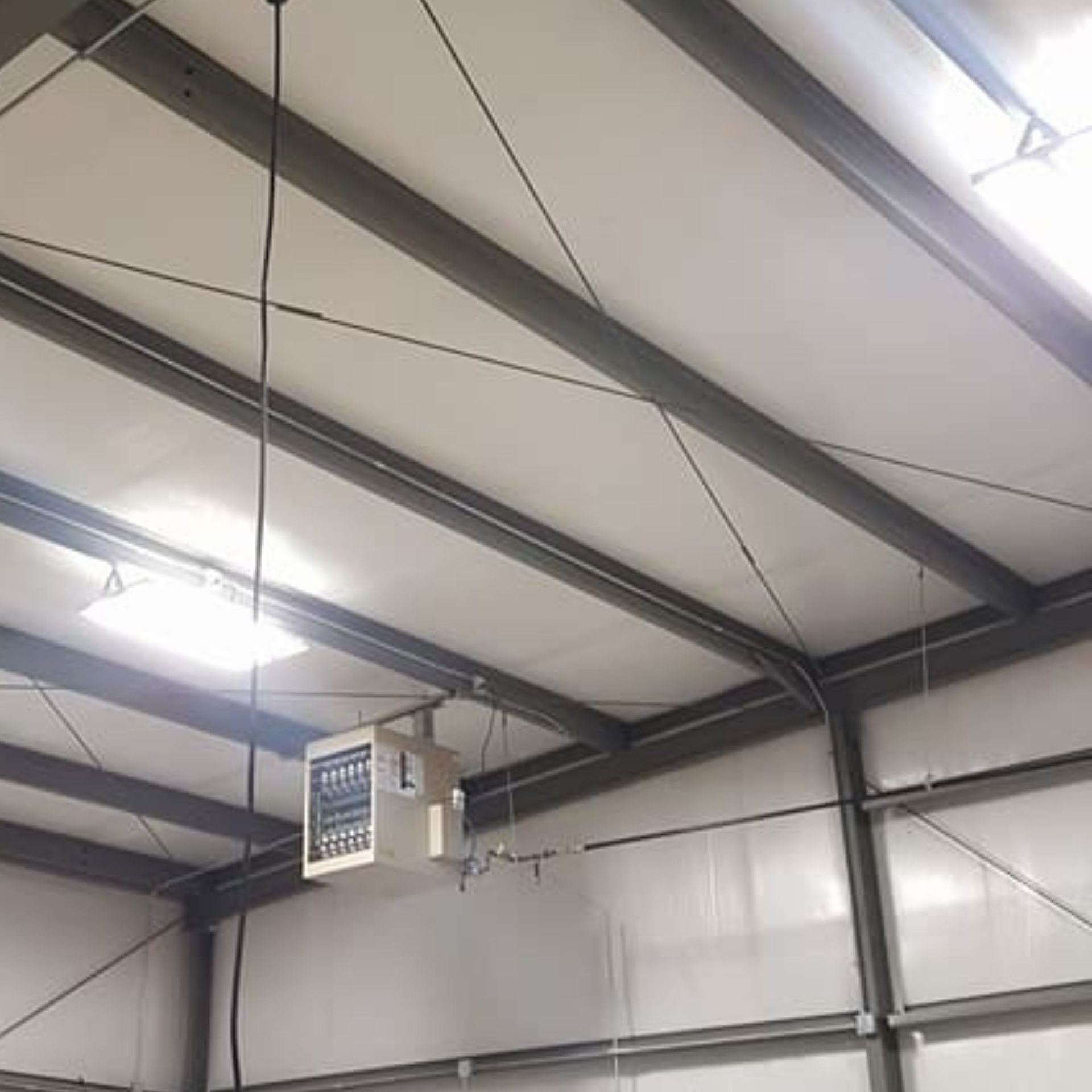 Harrington Electric LLC - A heater is hanging from the ceiling of a building.