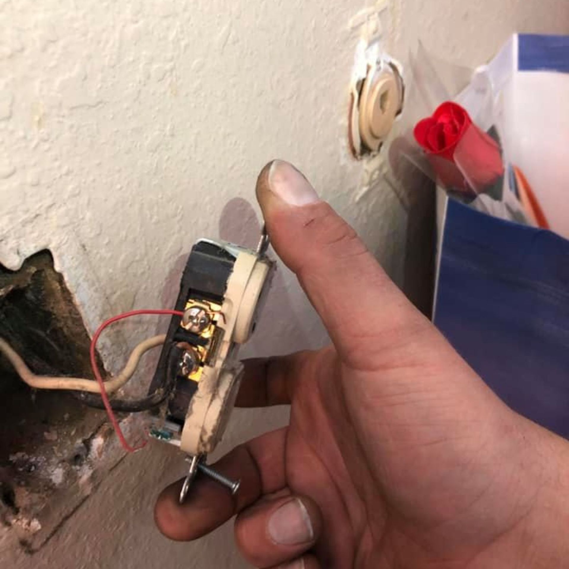 Harrington Electric LLC - A person is holding a light switch in their hand
