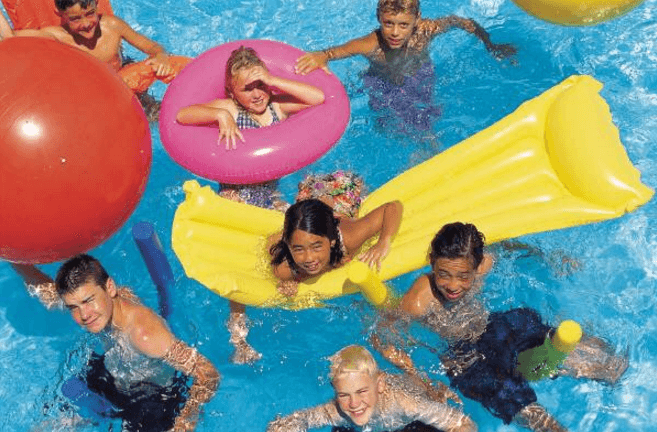 A group of children are playing in a swimming pool