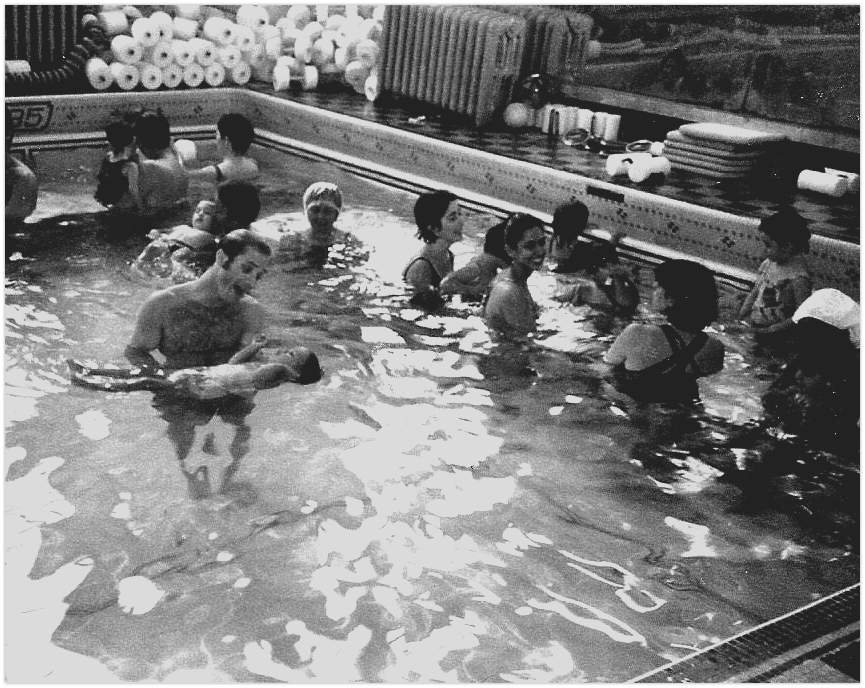 A black and white photo of people in a swimming pool