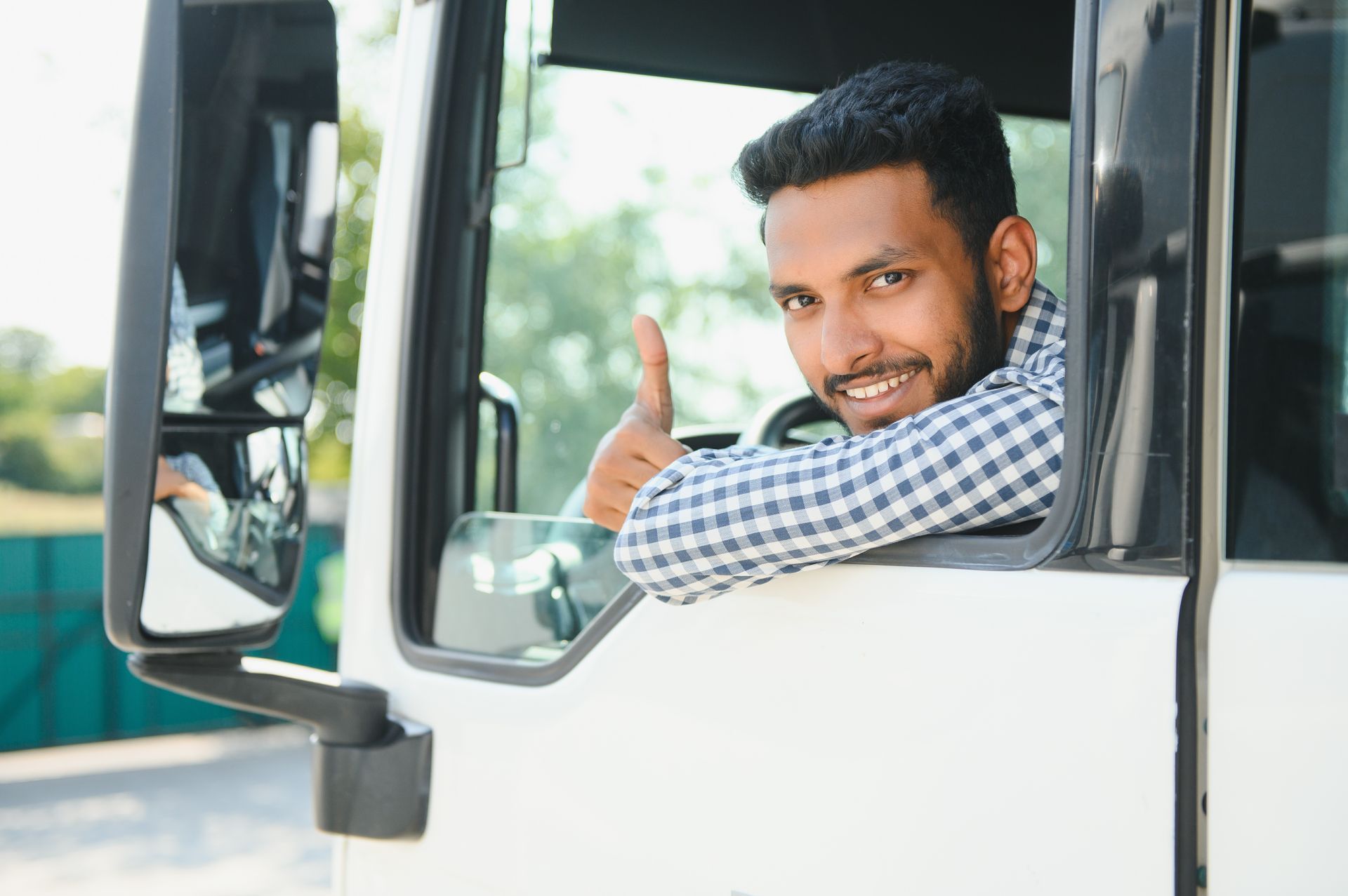 Man in truck cab gives thumbs up. Man in truck cab gives thumbs up.