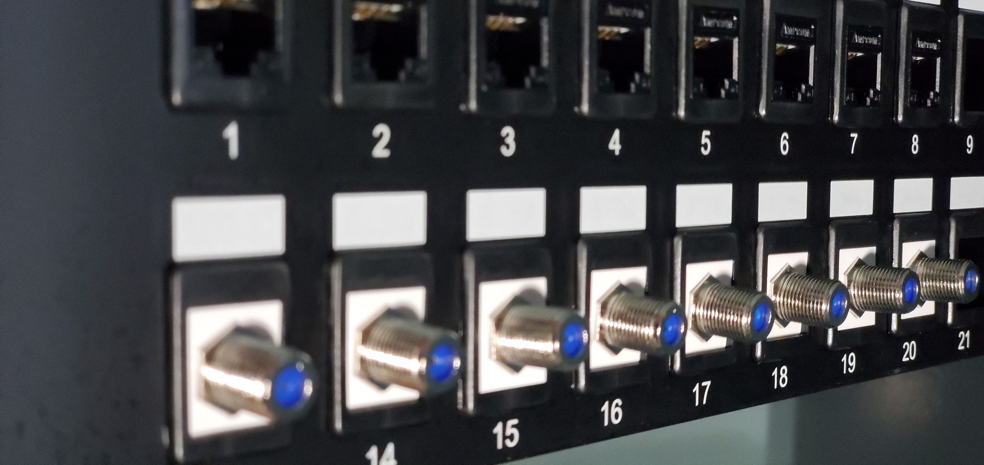 Black patch panel with numbered ports and coaxial connectors.