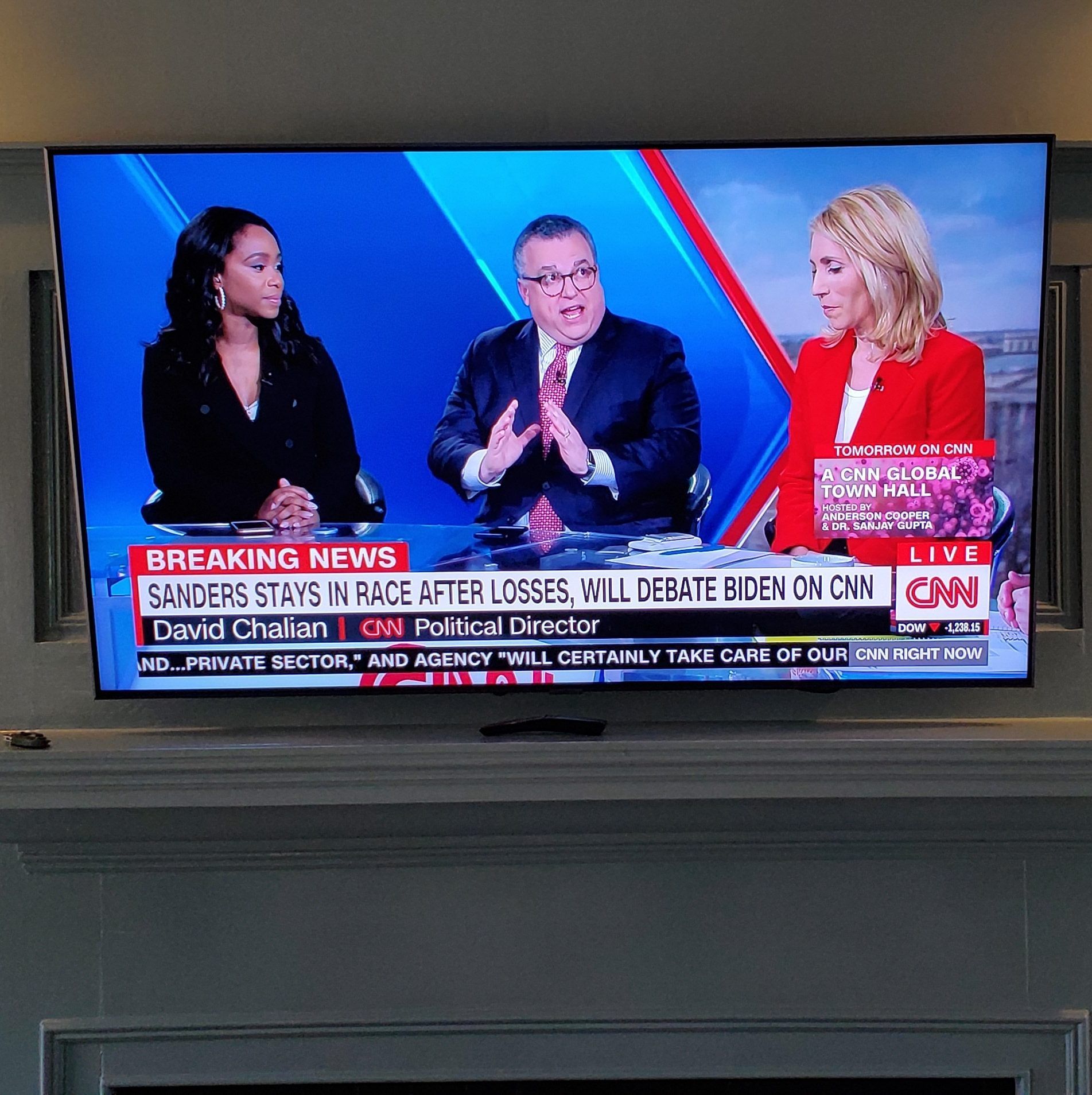 CNN news anchors on a television screen reporting breaking news. The lower text reads