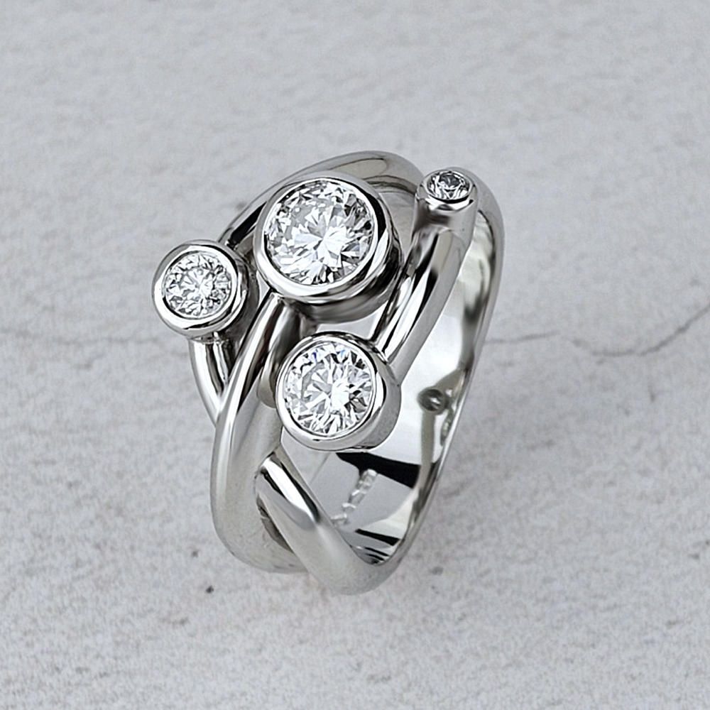 A platinum dress ring with four diamonds of different sizes in an asymmetric design