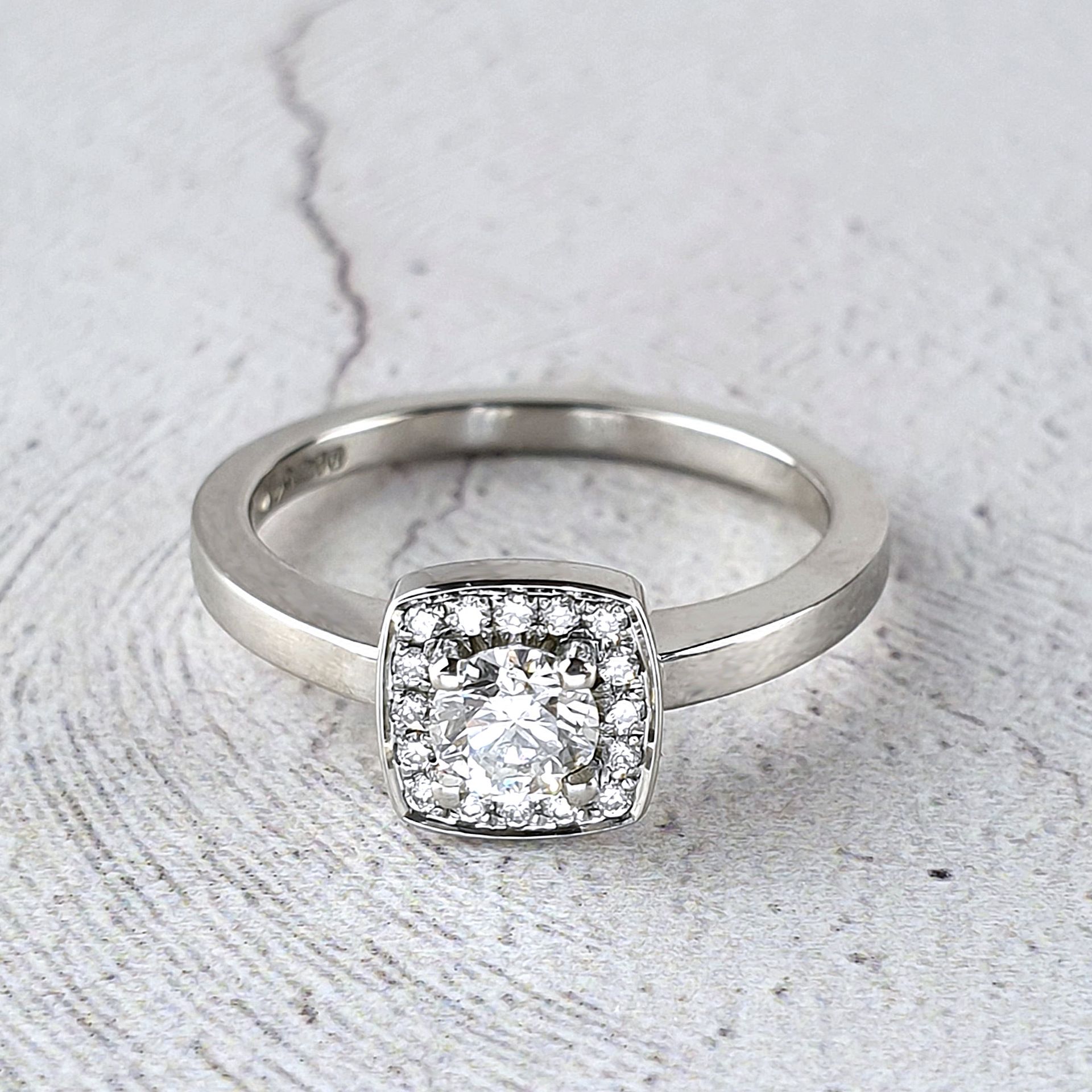 Cushion shaped halo ring with diamonds