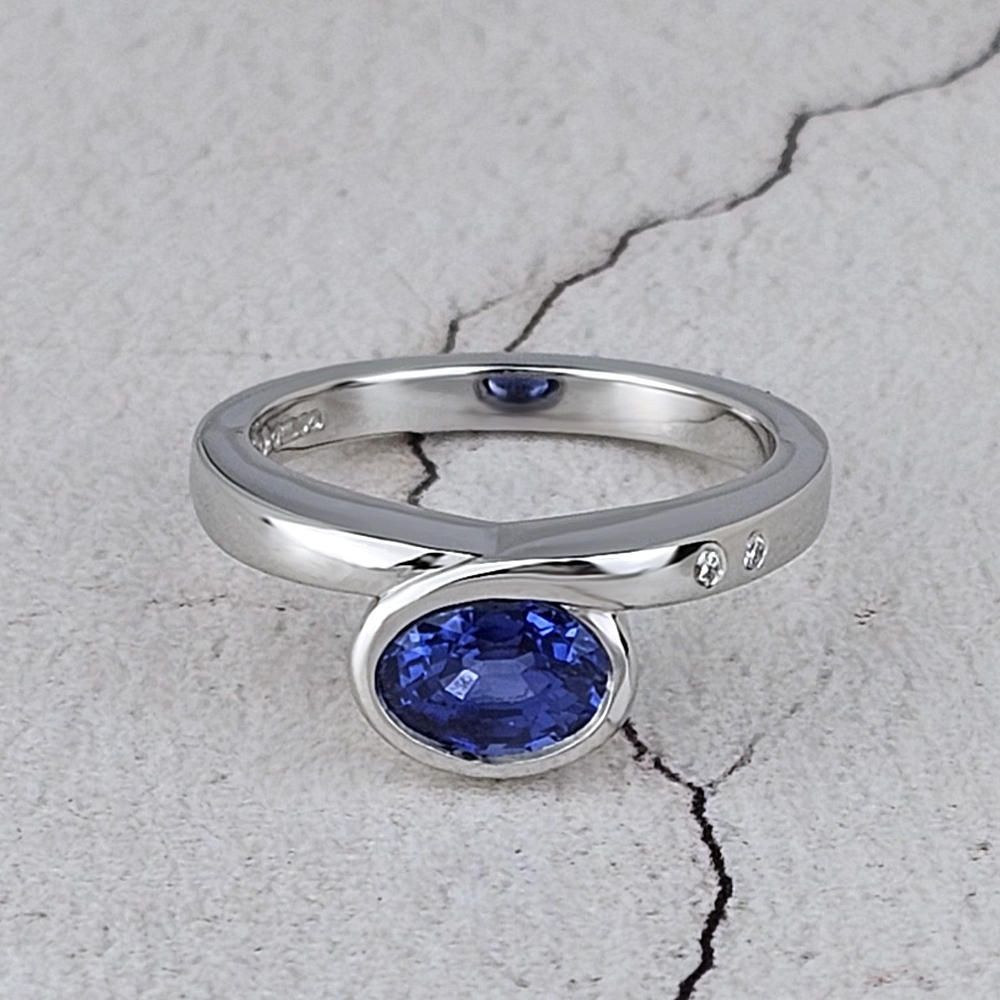 Infinity ring with an oval blue sapphire